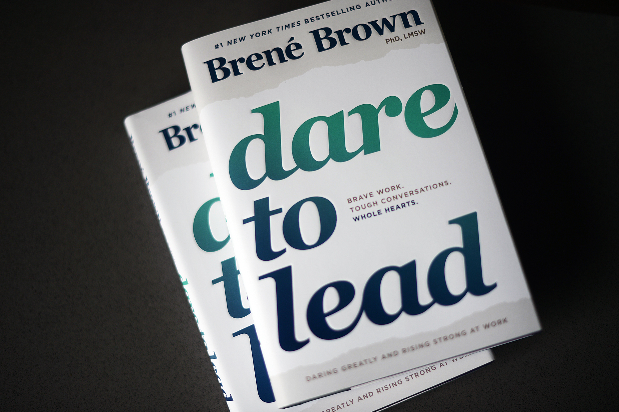 Two copies of Dare to Lead by Brene Brown sitting on a desk