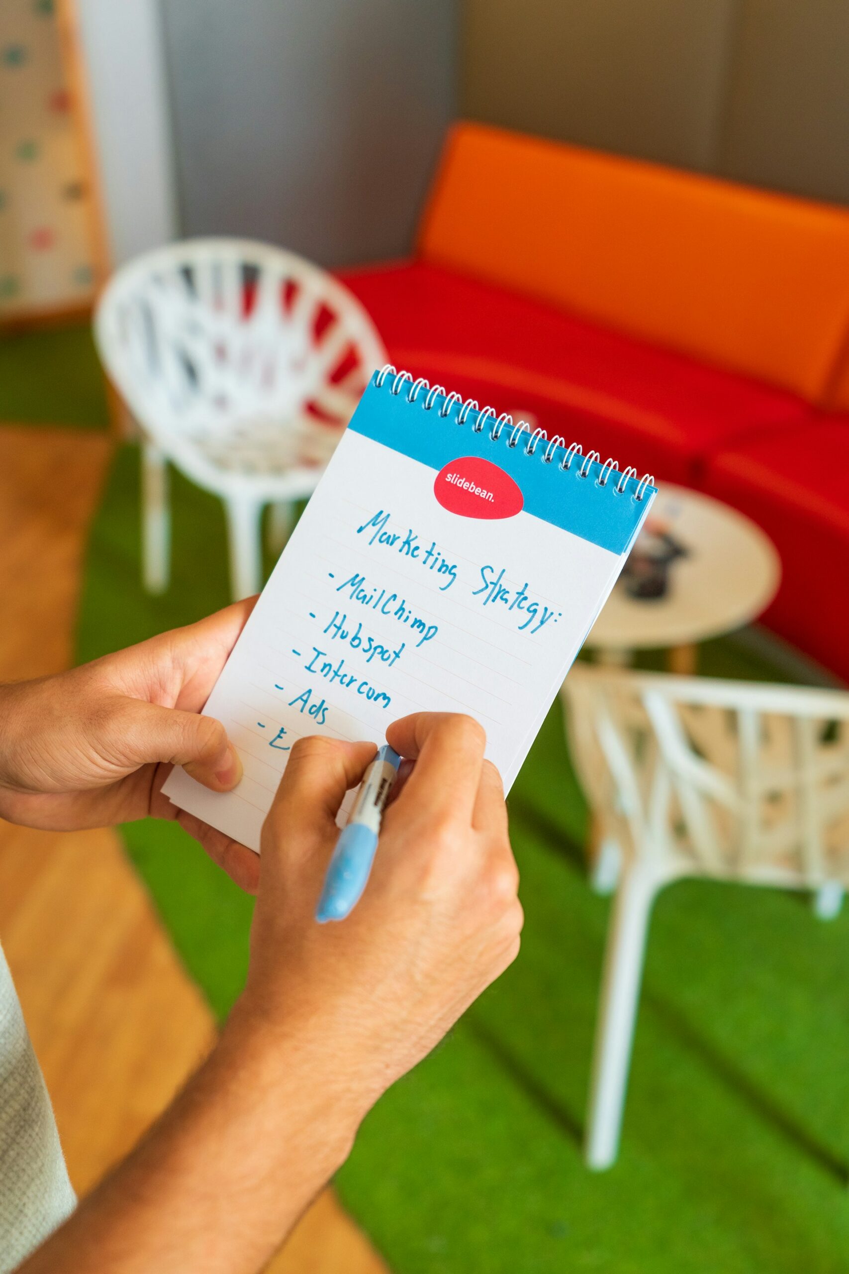 A person holding a marketing strategy written on a notebook