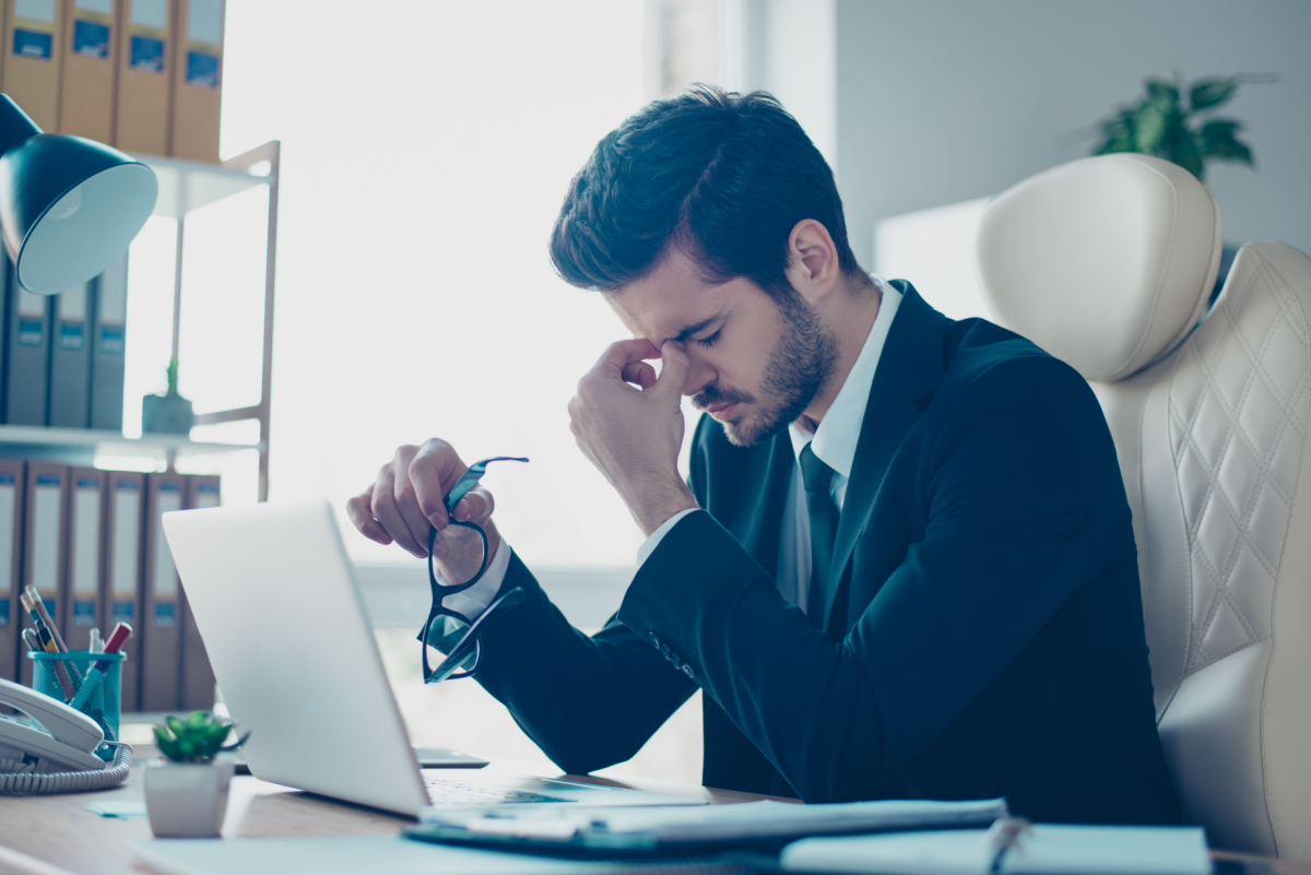 Lawyer looking frustrated while holding his head in his hands