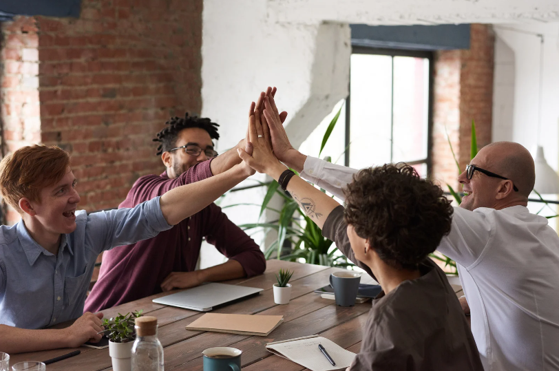 A group of business people encouraging one another and high fiving