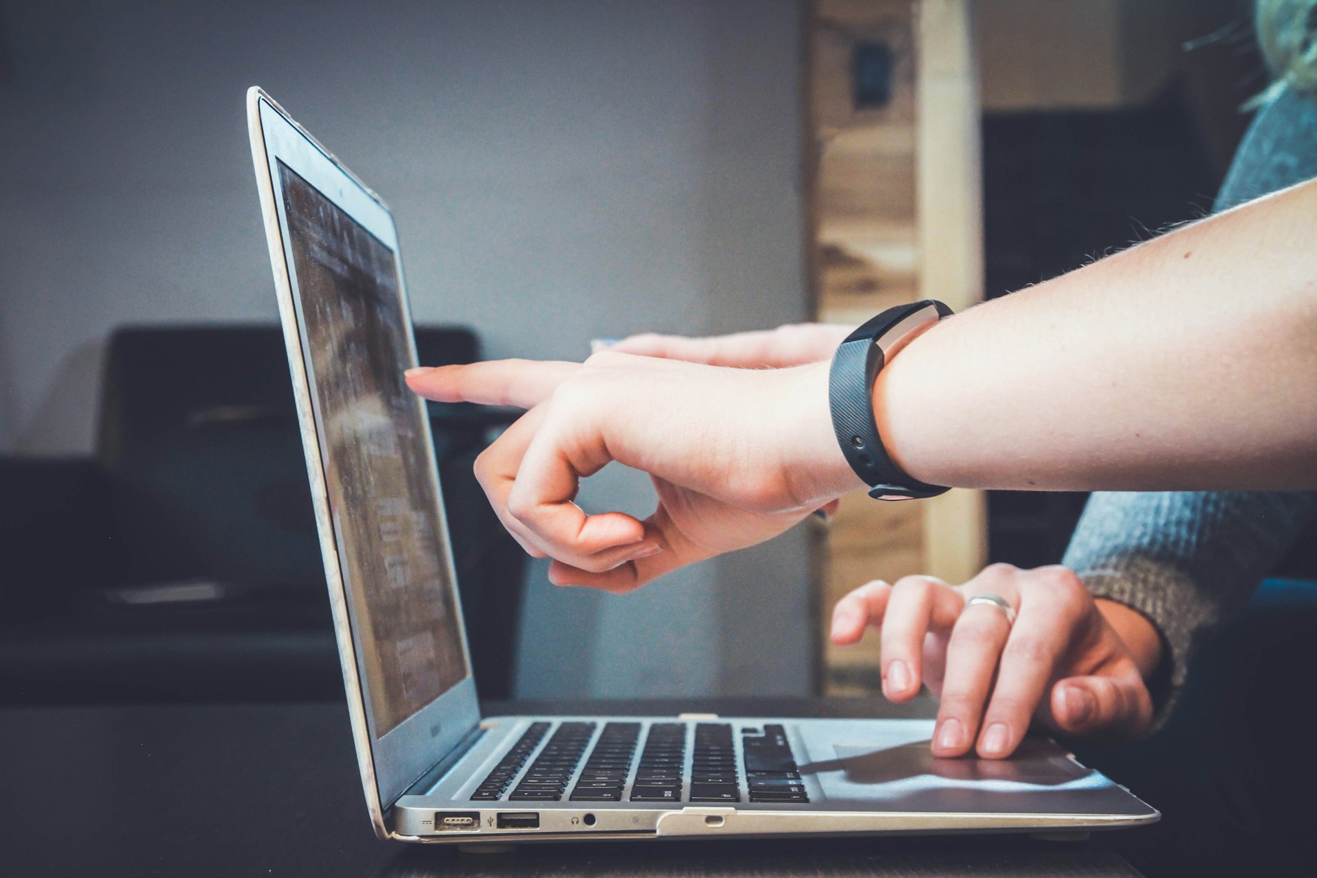 A small business owner looking at their website on a laptop and pointing