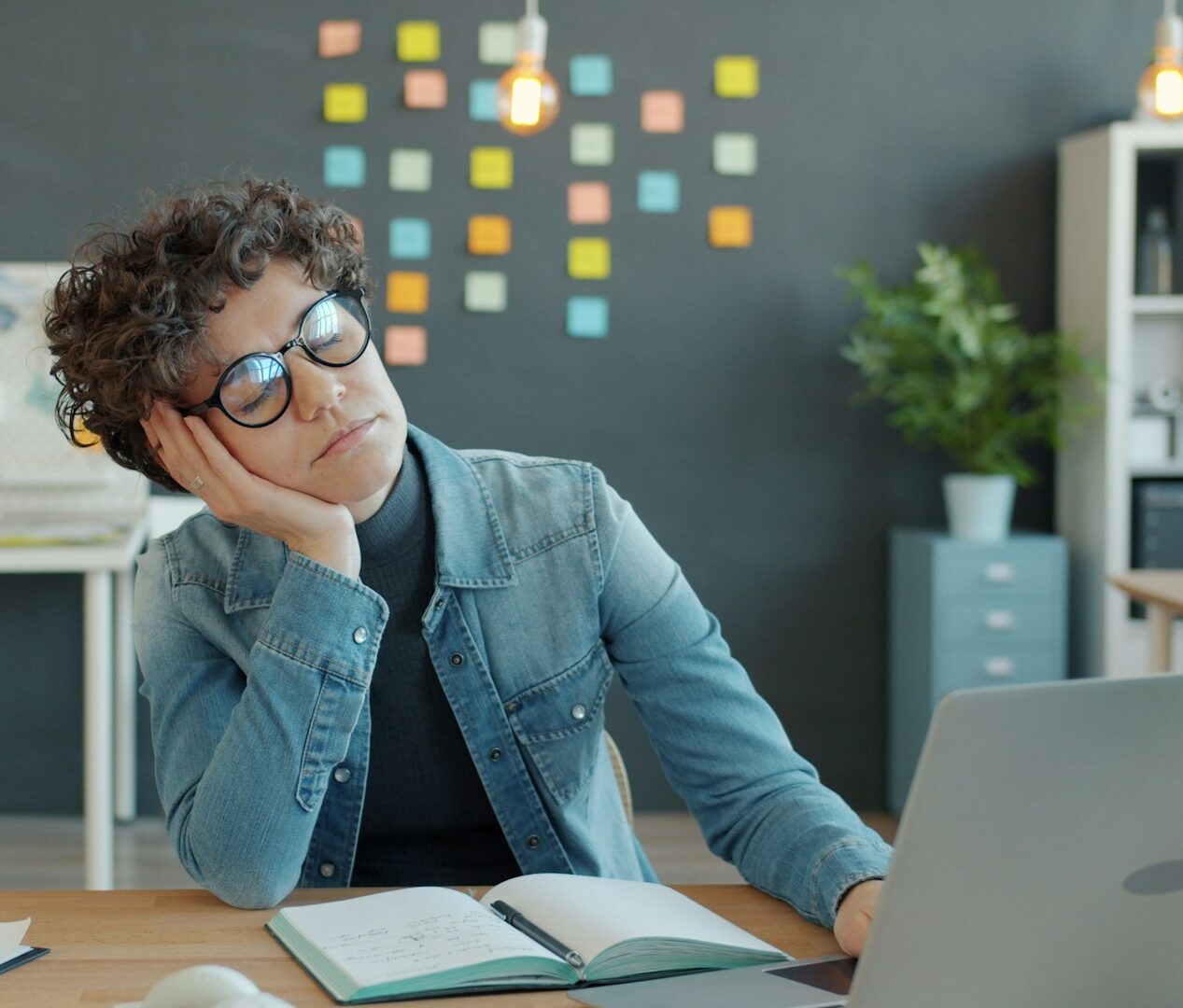 An employee with ADHD sitting at their desk daydreaming while juggling multiple tasks